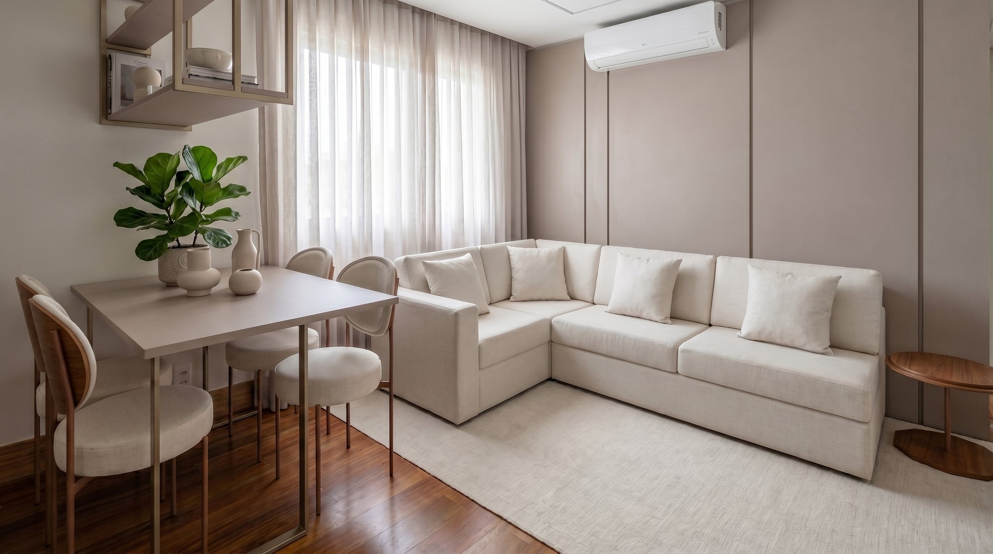 Estar do studio com sofá de canto em linho claro, mesa para quatro com cadeiras estofadas, estante metálica suspensa, cortina de linho e parede com frisos